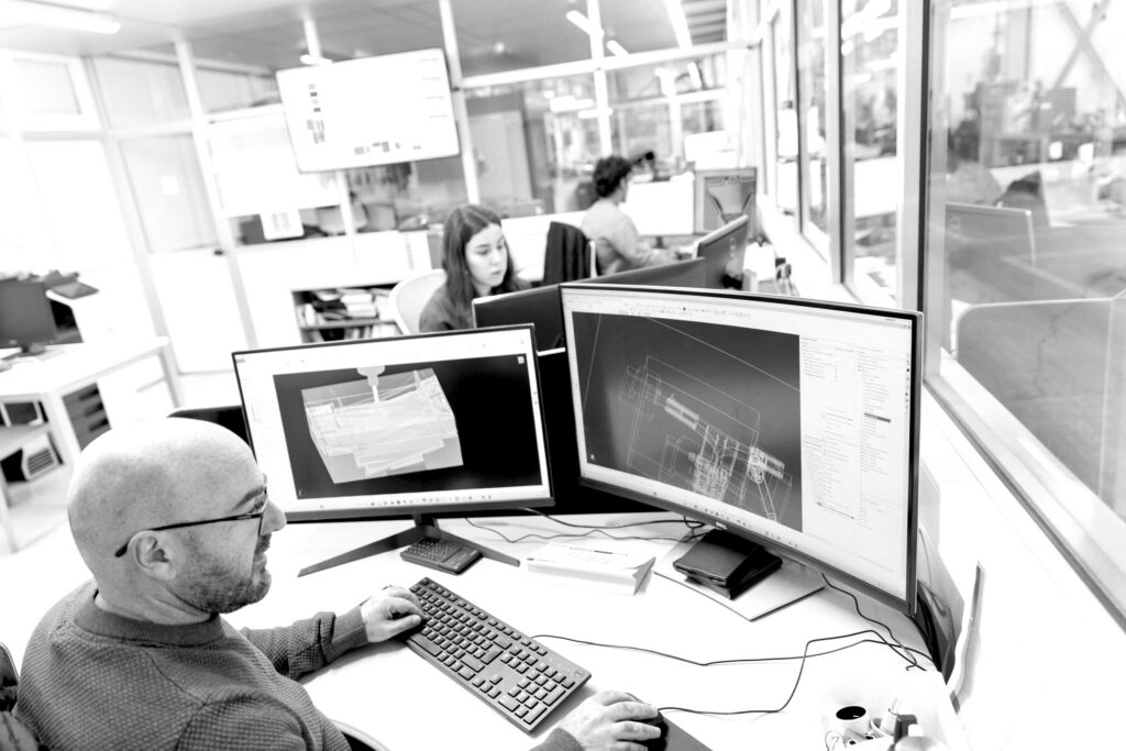 Ingeniero trabajando con software CAD en oficina técnica para servicios de ingeniería y diseño industrial.