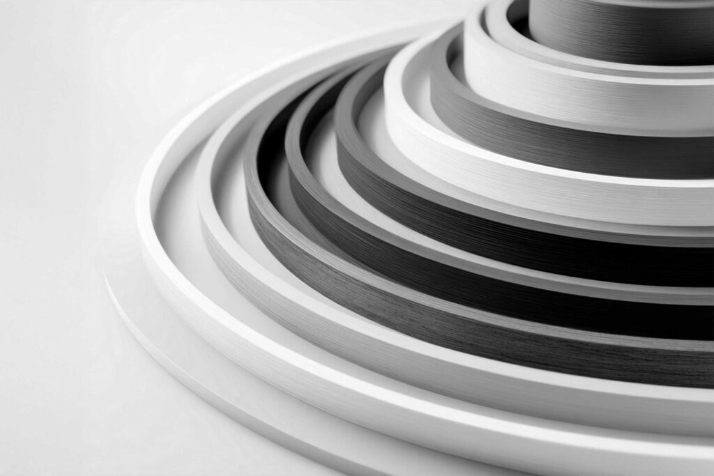 Perfiles y cantos PVC/ABS obtenidos mediante proceso de extrusión industrial.